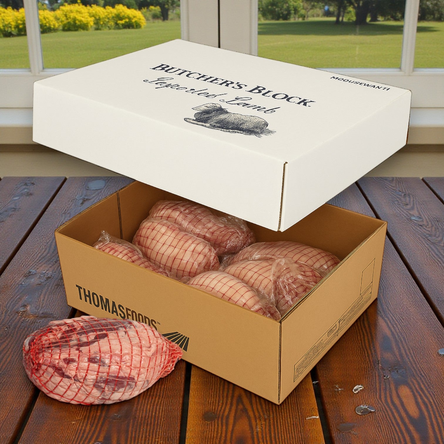 A box of Butchers Block Boneless Halal Lamb Leg – Frozen (5/6 lb avg, 26 lb avg) sits open on a wooden table, showing several individually wrapped boneless halal lamb leg roasts inside.