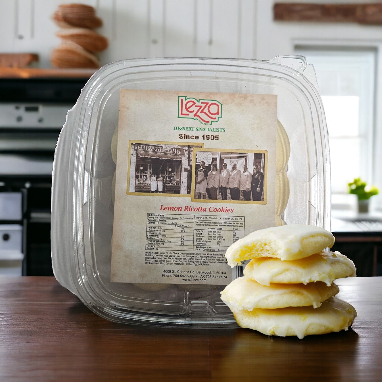 A plastic container labeled "Easy Lunches Lemon Ricotta Cookies" sits on a wooden table, with four frosted cookies partially stacked on the right side. The label includes a historical photo and text, highlighting the zesty lemon flavor and creamy ricotta in these delightful Lemon Ricotta Cookies. One container contains 16 cookies.