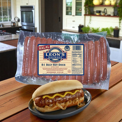 A 5 lb pack of Amylu’s Halal Hot Dogs—Leon's Sausage 8:1 Beef Hot Dogs (40 total)—is on an outdoor table, with a cooked hot dog in a bun topped with onions and mustard on a plate in front.