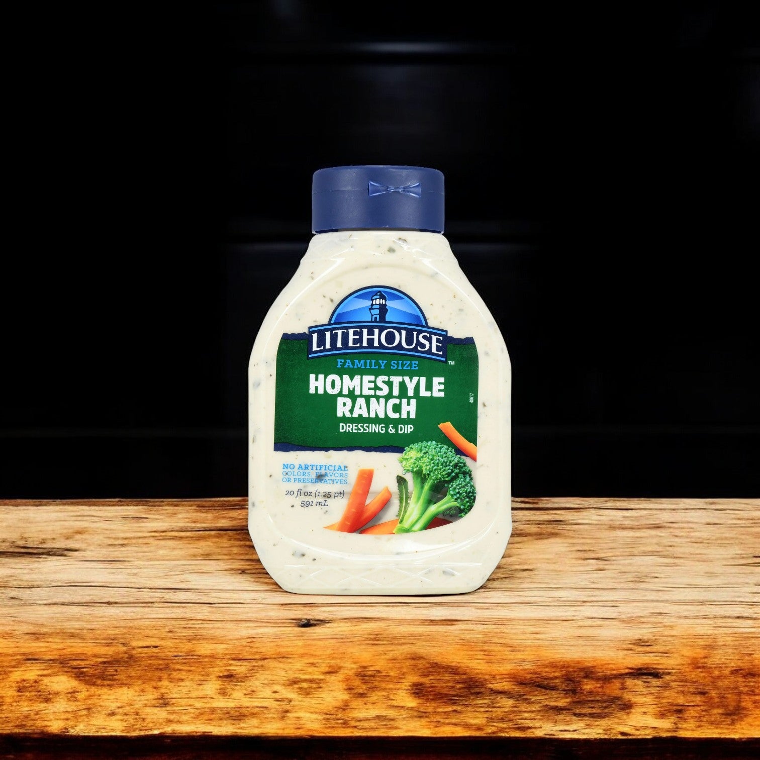 A bottle of Litehouse Homestyle Ranch dressing and dip rests on a wooden surface, with a dark background. Perfectly paired with the easylunches' Game Day Bundle, it complements everything from Red Baron's Deep Dish Pizzas to Tyson's Buffalo Hot Wings.