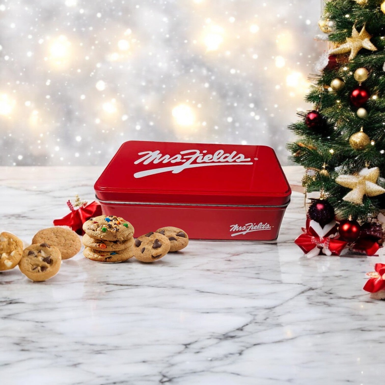 A vibrant red tin from the Lou Malnati's Deep Dish & Mrs. Fields 3 Pack Combo by Easy Lunches rests gracefully on a marble surface, surrounded by an assortment of mouthwatering cookies. In the background, a beautifully adorned Christmas tree twinkles with lights, setting the ideal holiday scene for enjoying these delightful treats.