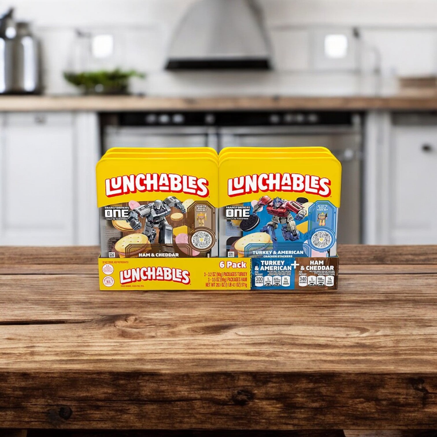 Two Lunchables boxes are displayed on a wooden table in a kitchen. The left box features Ham & Cheddar, while the right one is the Lunchables Cracker Stackers Snack Kit Variety Pack, 6 pk., providing convenient on-the-go snacking options with Turkey & American and Ham & Cheddar.