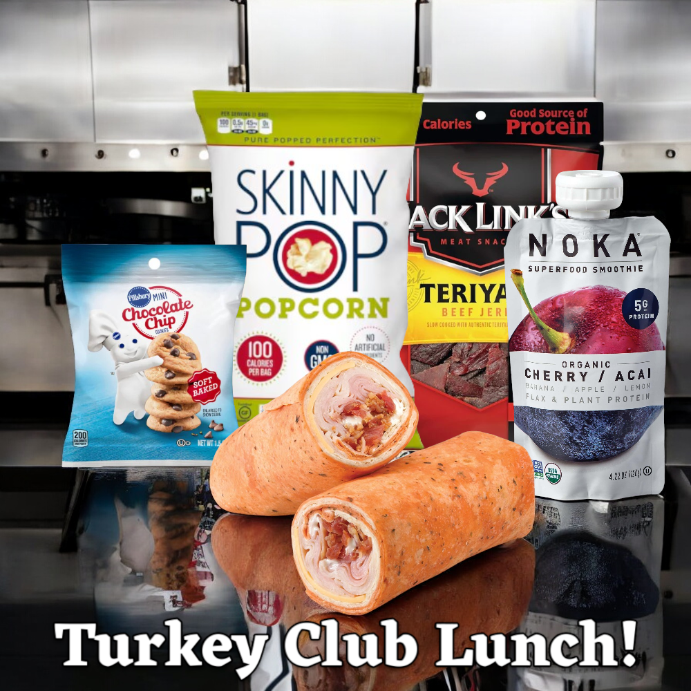 A display of the "Turkey Club Lunch!" by Easy Lunches featuring a turkey club wrap accompanied by packaged snacks such as a SkinnyPop popcorn bag, Jack Link's teriyaki beef jerky, a Noka cherry acai smoothie pack, and Pillsbury mini chocolate chip cookies. Text reads "Turkey Club Lunch Combo! A Total of 5 Items!