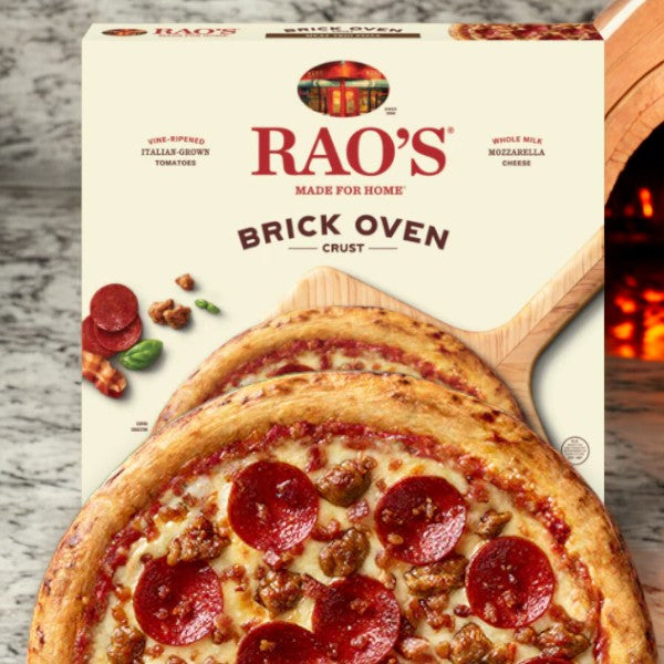 Image of Rao's Meat Trio Frozen Pizza box on a marble countertop, with a ready-to-bake uncured pepperoni and sausage pizza partially visible in front of the box.