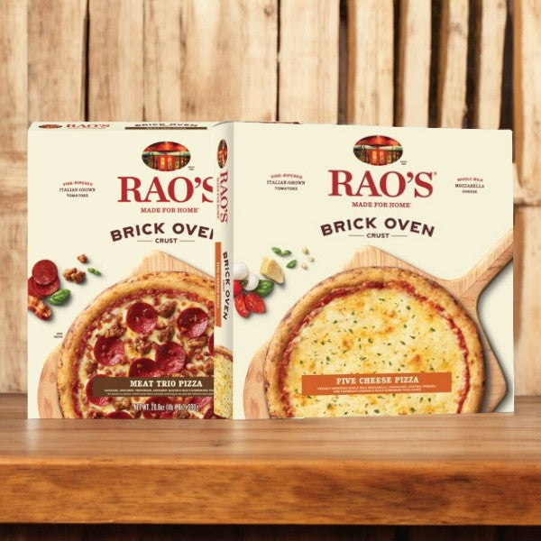 Two boxes from the Easy Lunches Rao's Pizza Bundle are on display, one labeled "Meat Trio Pizza" and the other labeled "Five Cheese Pizza," set against a wooden background.