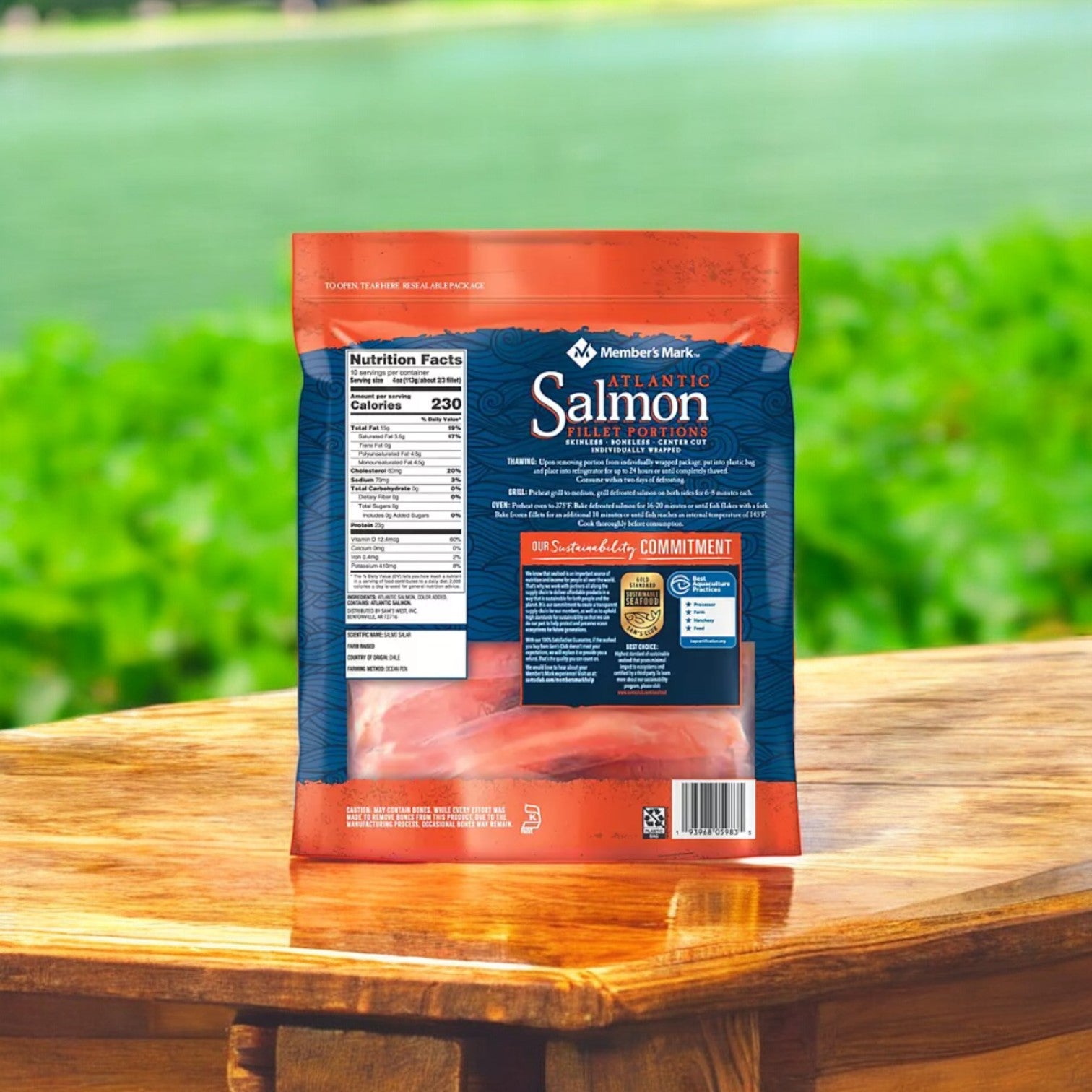 A bag of Member's Mark Atlantic Salmon Fillet Portions, 40 oz., rich in omega-3 fatty acids, sits on a wooden table with a blurred green outdoor background. The packaging emphasizes nutrition facts and quality commitments, reflecting support for sustainable fisheries.