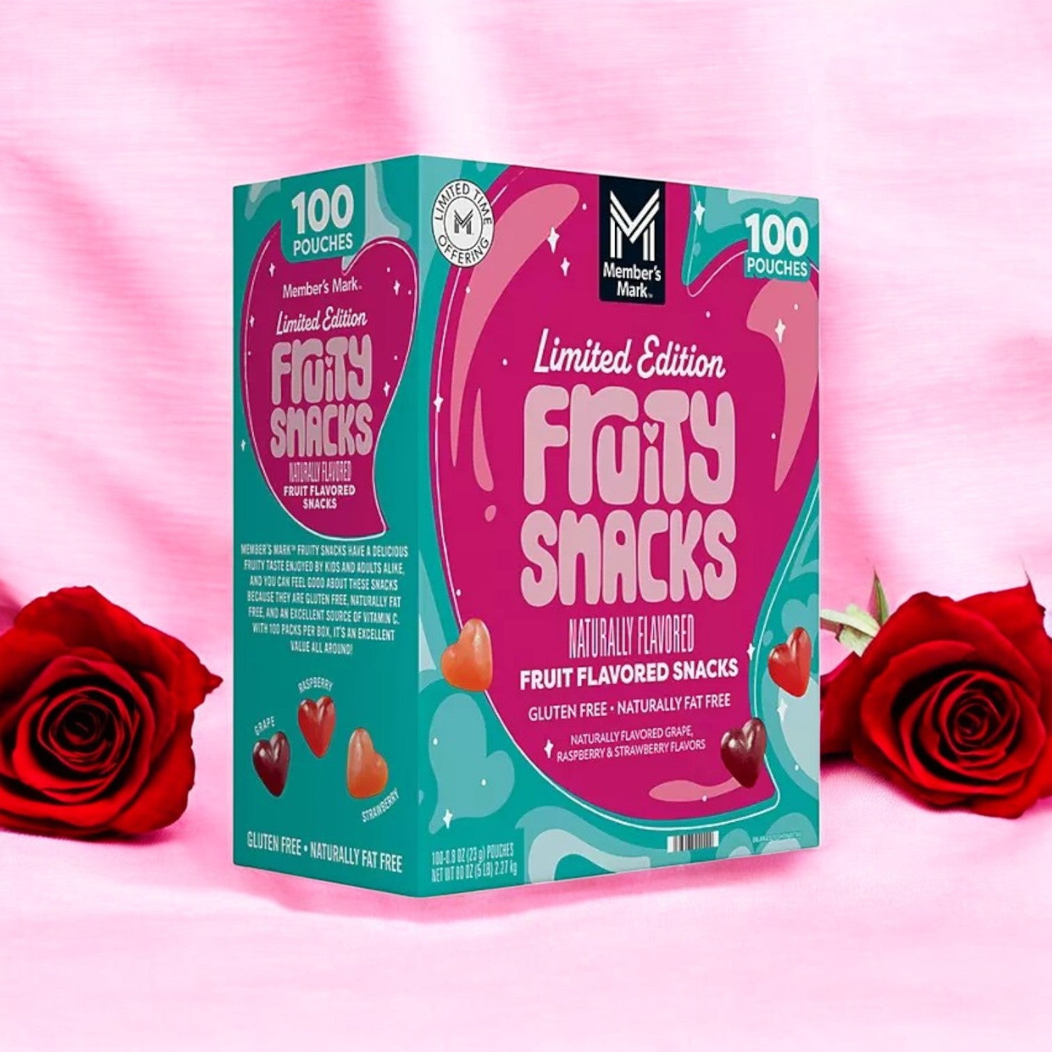 A box of Member's Mark Valentine's Day Fruity Snacks, featuring a heart-shaped design package on a pink background with red roses. These naturally flavored, gluten-free snacks come in 100 individually wrapped pouches.