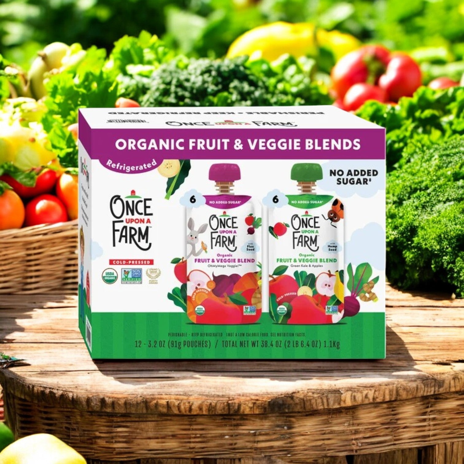 A basket filled with fresh veggies holds a box of "Once Upon a Farm" Organic Fruit & Veggie Blend Variety Pack, featuring 6 OhMyMega Veggie and 6 Green Kale & Apples blends, in its vibrant packaging.