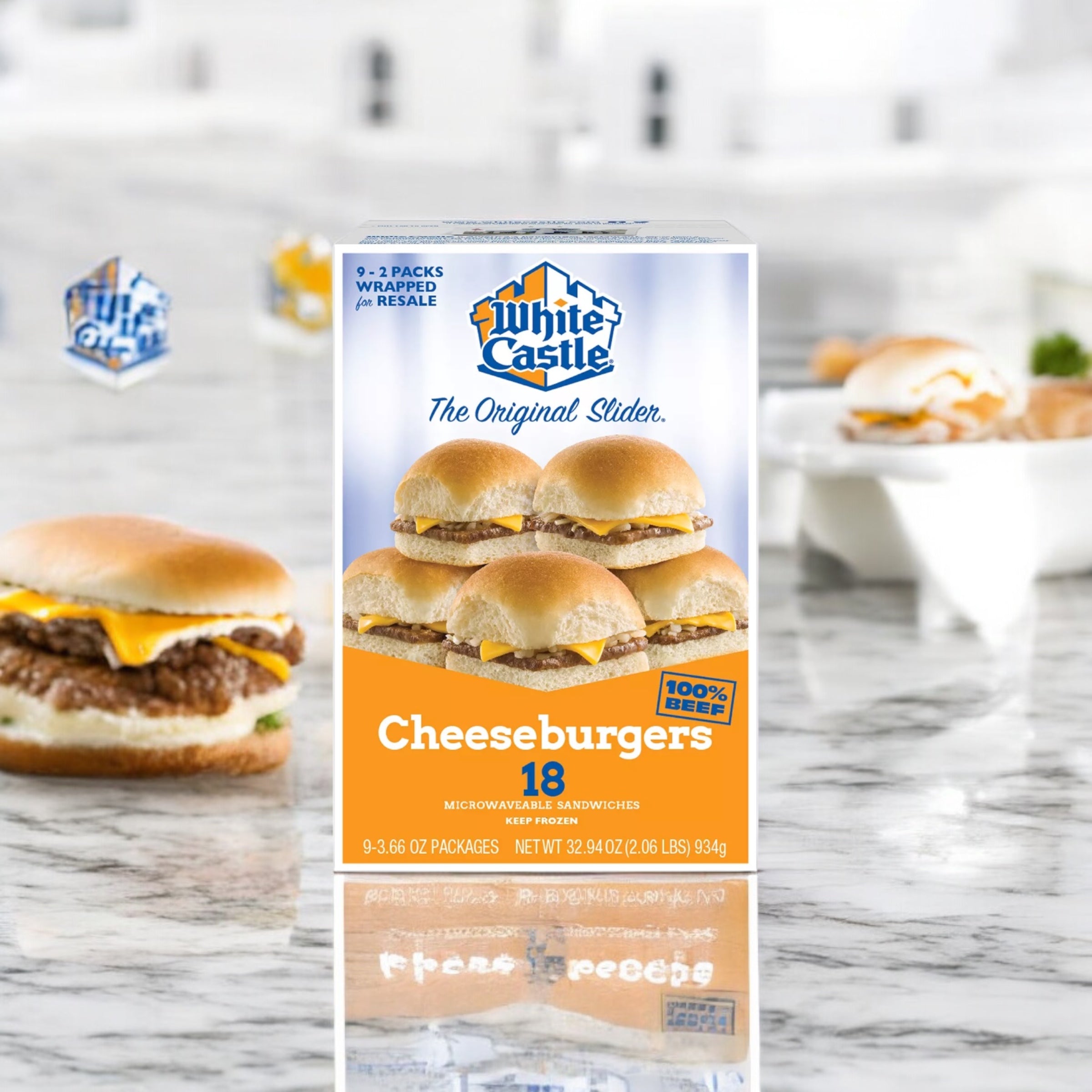 A box of White Castle Cheeseburger Sliders from Easy Lunches, containing 18 individually wrapped cheeseburger sliders, sits on a marble surface with another cheeseburger slider in the background.