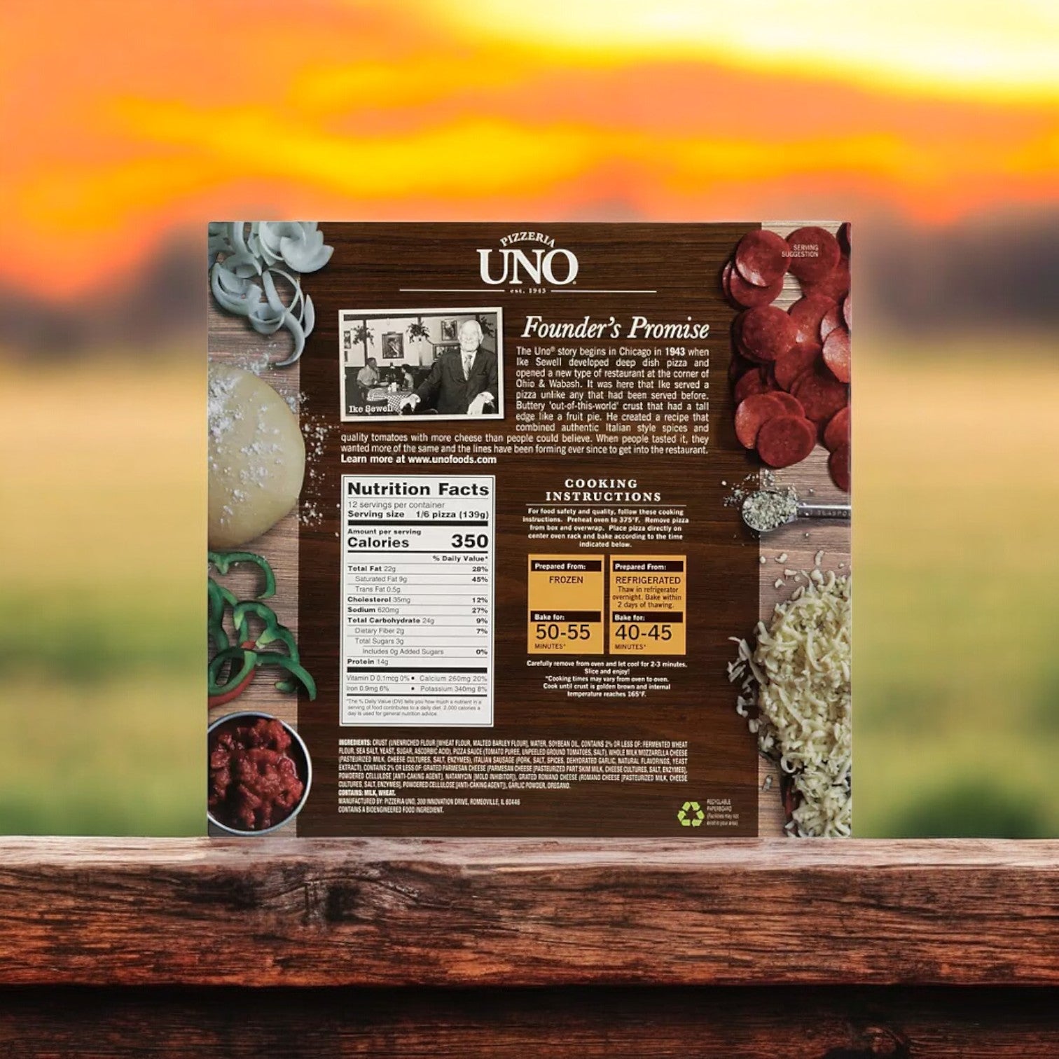 The Pizzeria Uno 9" Deep Dish Classic Sausage Pizza box, part of a case containing three packs and totaling six pizzas, displays nutritional information, the founder's story, and cooking instructions. In the background, an outdoor scene features a sunset that beautifully complements the rich flavors of their renowned deep dish pizza.