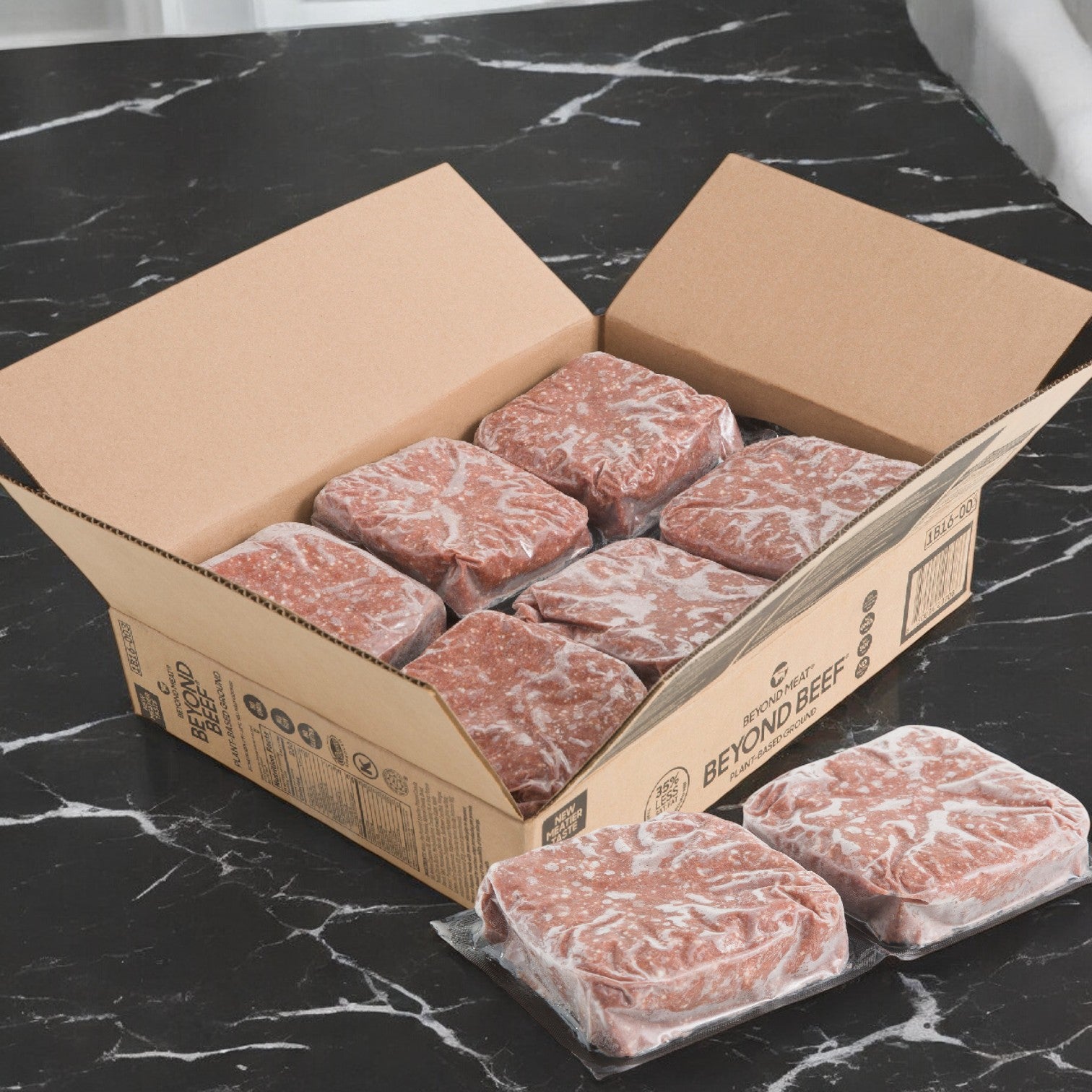 A cardboard box on a black marble surface contains six packages of Beyond Meat Plant-Based Ground Beef, each weighing 2 lbs., crafted with non-GMO ingredients.