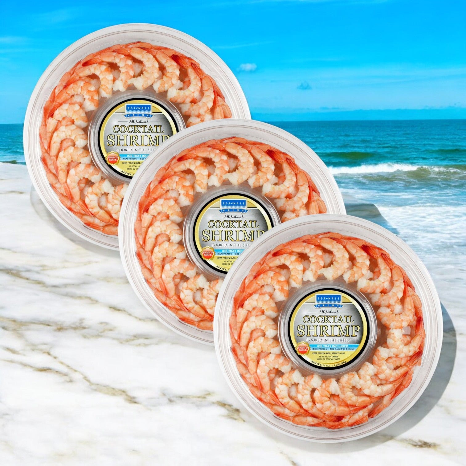 Three Easy Lunches Shrimp Platter-Seamazz Fully Cooked Cocktail Shrimp Ring 16 oz. packs are displayed on a marble surface by the beach—ready to serve at any seaside gathering.