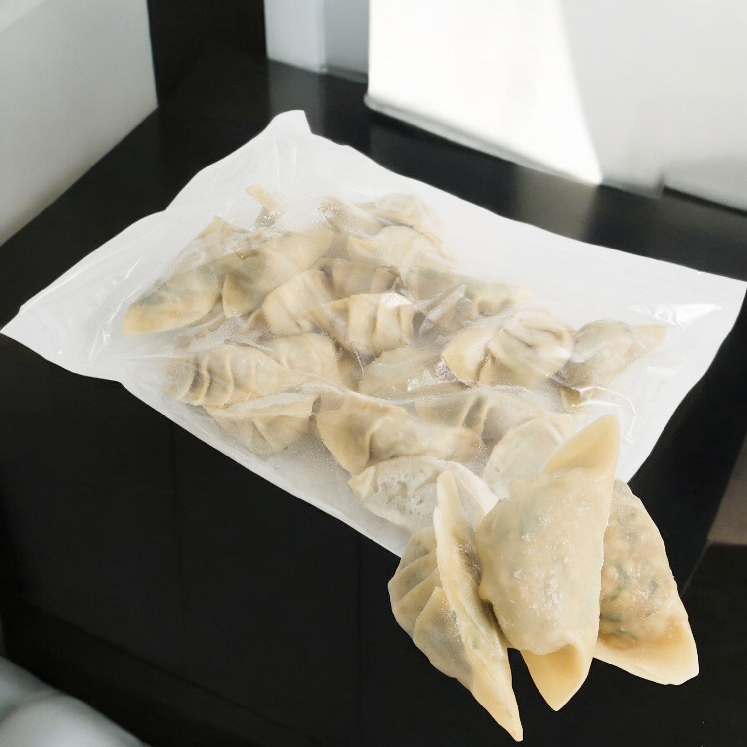 A black table showcases a vacuum-sealed bag of Phillip Foods Potsticker Vegetable Shiitake Mushroom, infused with authentic Chesapeake flavor.