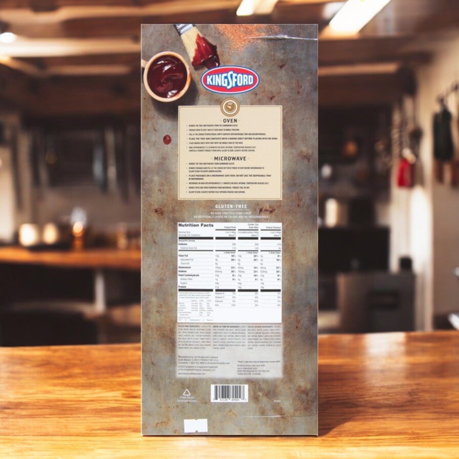 On a wooden kitchen table, the back of a Kingsford Combo Platter box displays cooking instructions and nutrition facts for the Pulled Pork, St. Louis Style Center Cut Pork Ribs, and Pulled Chicken.