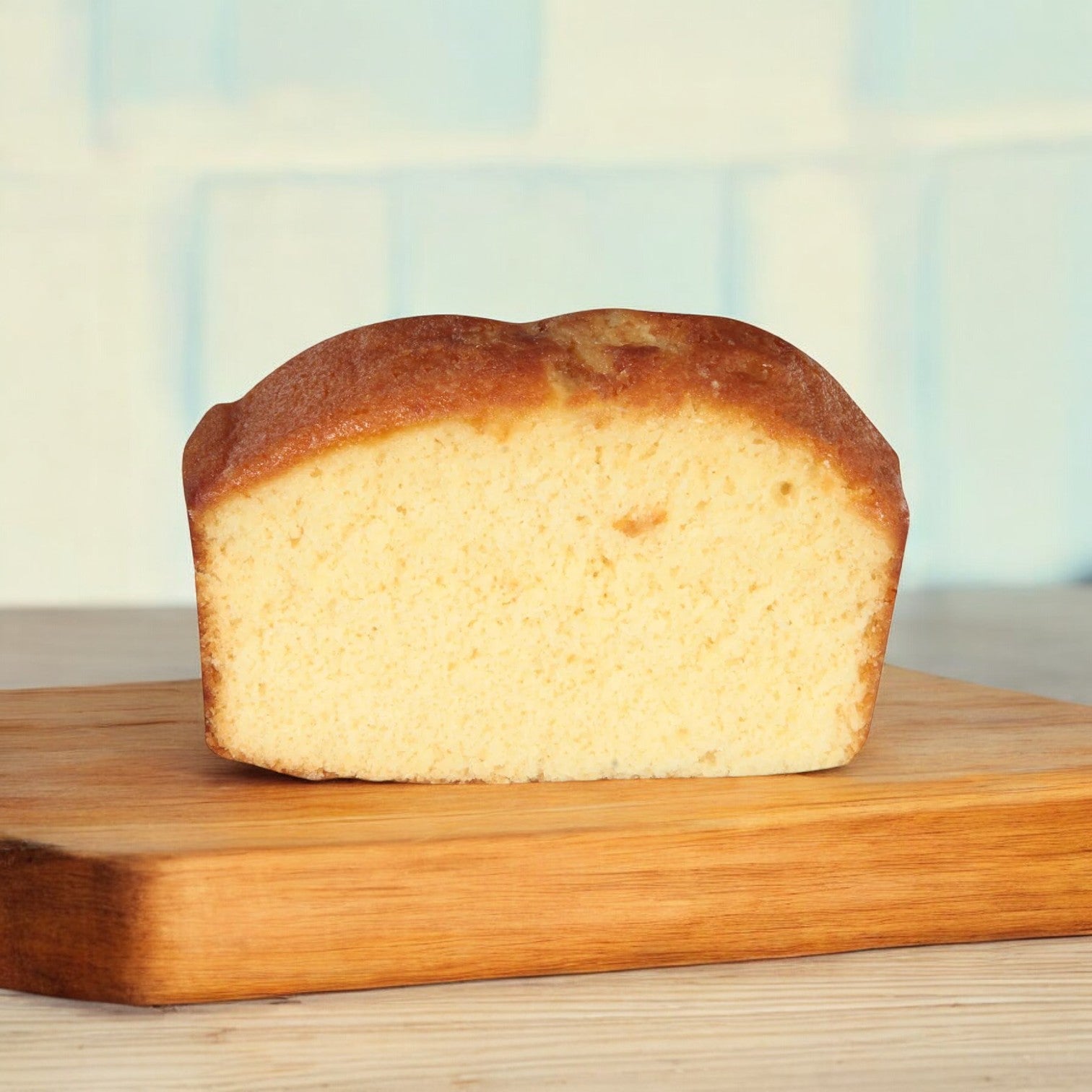 A box of 24 individually wrapped Sara Lee Pound Cakes from Easy Lunches is displayed on a wooden cutting board against a light blue tiled background.