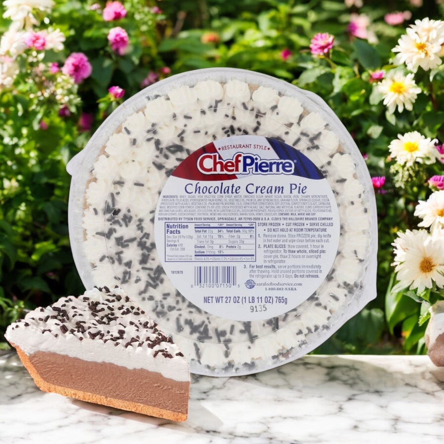 A Chef Pierre Chocolate Cream Pie, a 10-inch frozen dessert with decadent chocolate filling, sits outdoors surrounded by blooming flowers. A slice of the pie is visible in front.