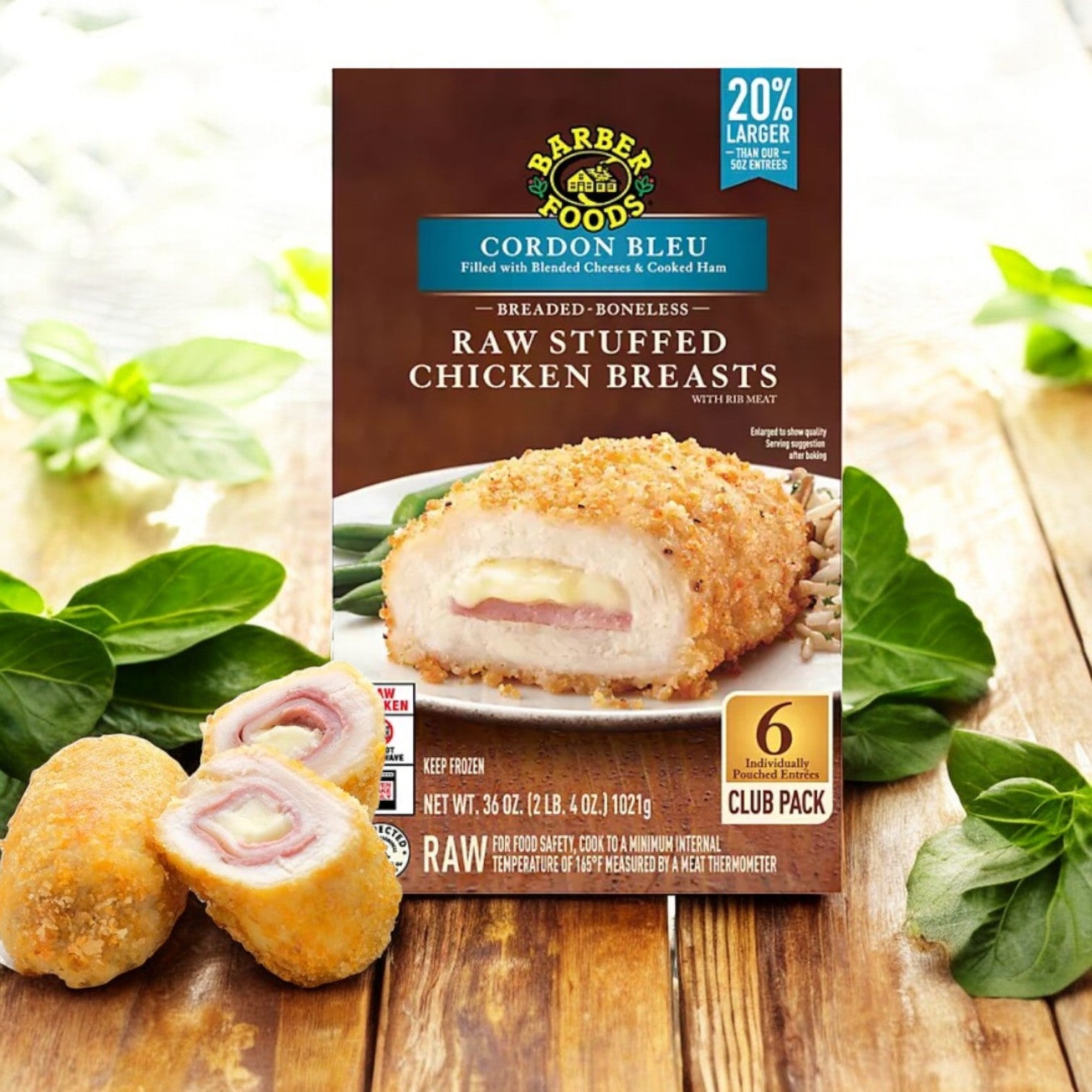 A box of Barber Foods Stuffed Cordon Bleu Chicken Breast, Frozen, 6 ct, is on a wooden surface with green leaves. This product offers gourmet-quality raw stuffed chicken breasts showcased enticingly on the package.