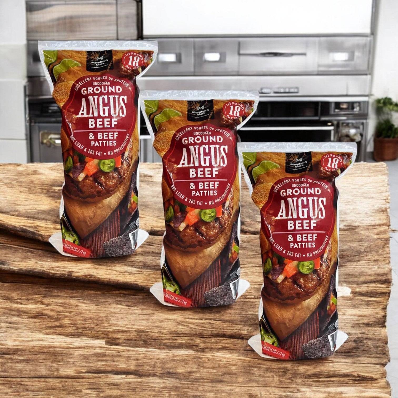 Three packs of Member's Mark 80/20 Ground Angus Beef Patties are displayed on a wooden kitchen surface, ready for grilling.