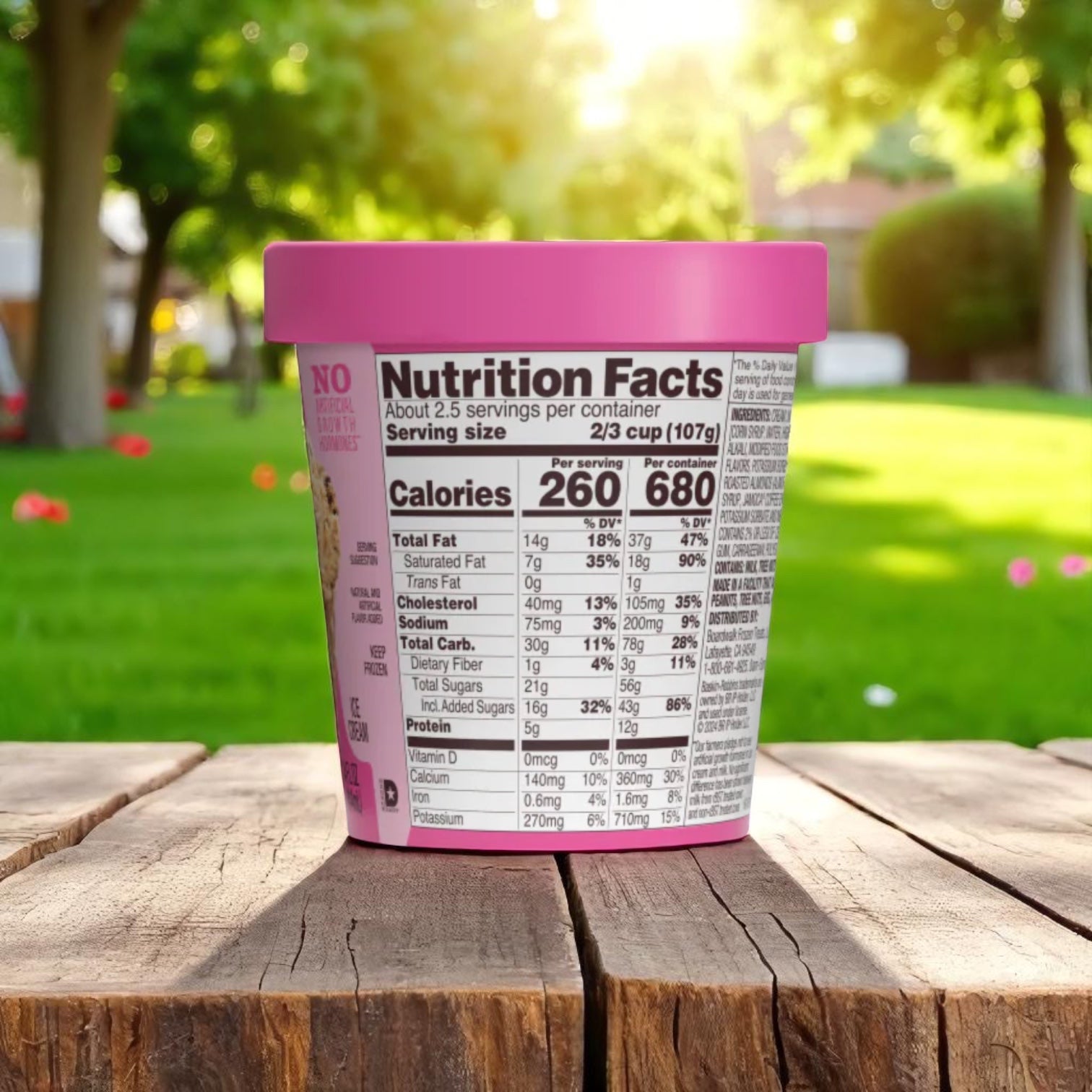 A 14 oz container of Easy Lunches Baskin Robbins Jamoca Almond Fudge ice cream with a pink lid sits outdoors, showing nutrition facts and suggesting a tasty mix of coffee ice cream and roasted almonds.