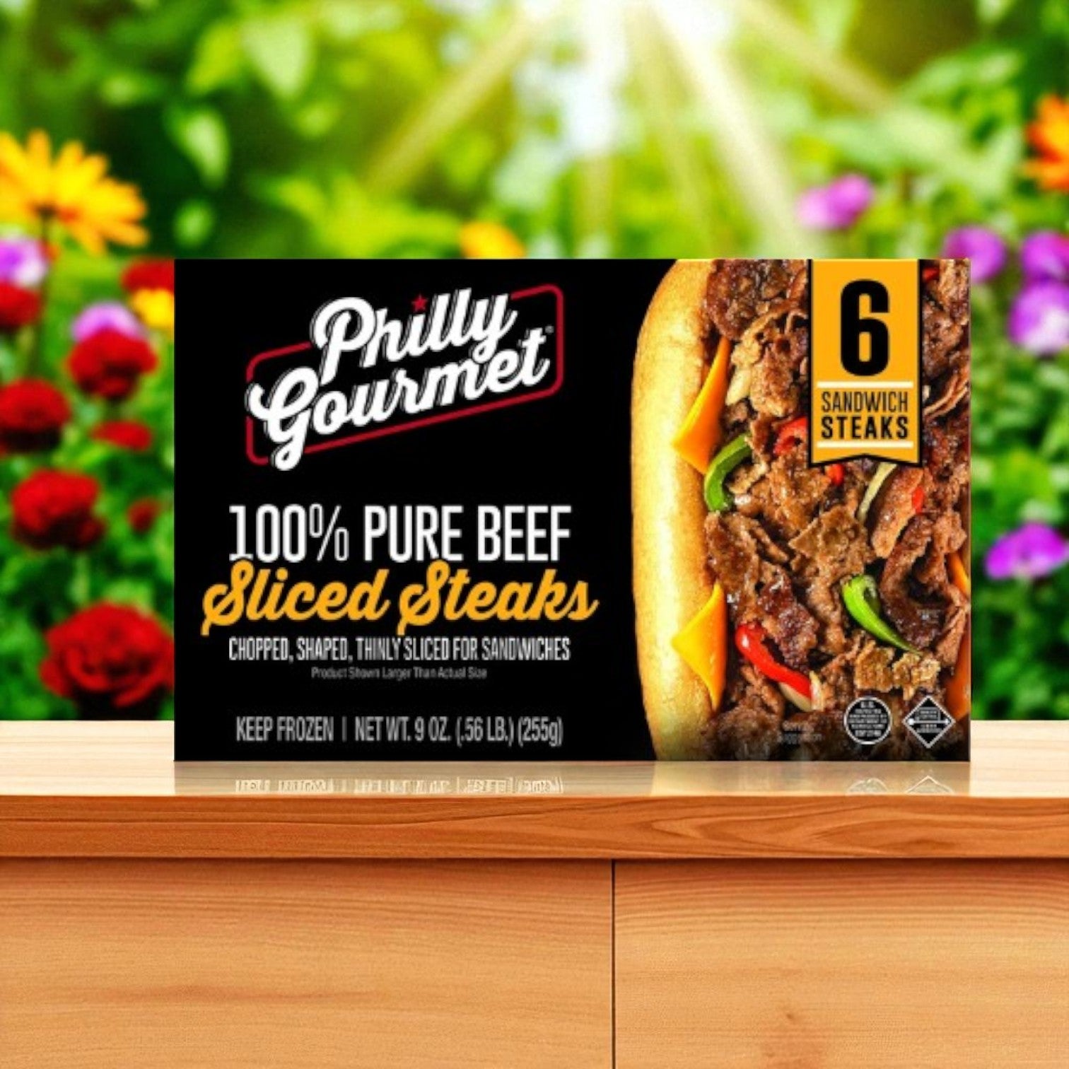 Philly's Gourmet Steaks, 100% Pure Beef Sliced-1 Pack, features 6 sandwich steaks arranged on a wooden surface with a vibrant flower garden in the background—perfect for making delicious cheesesteaks.