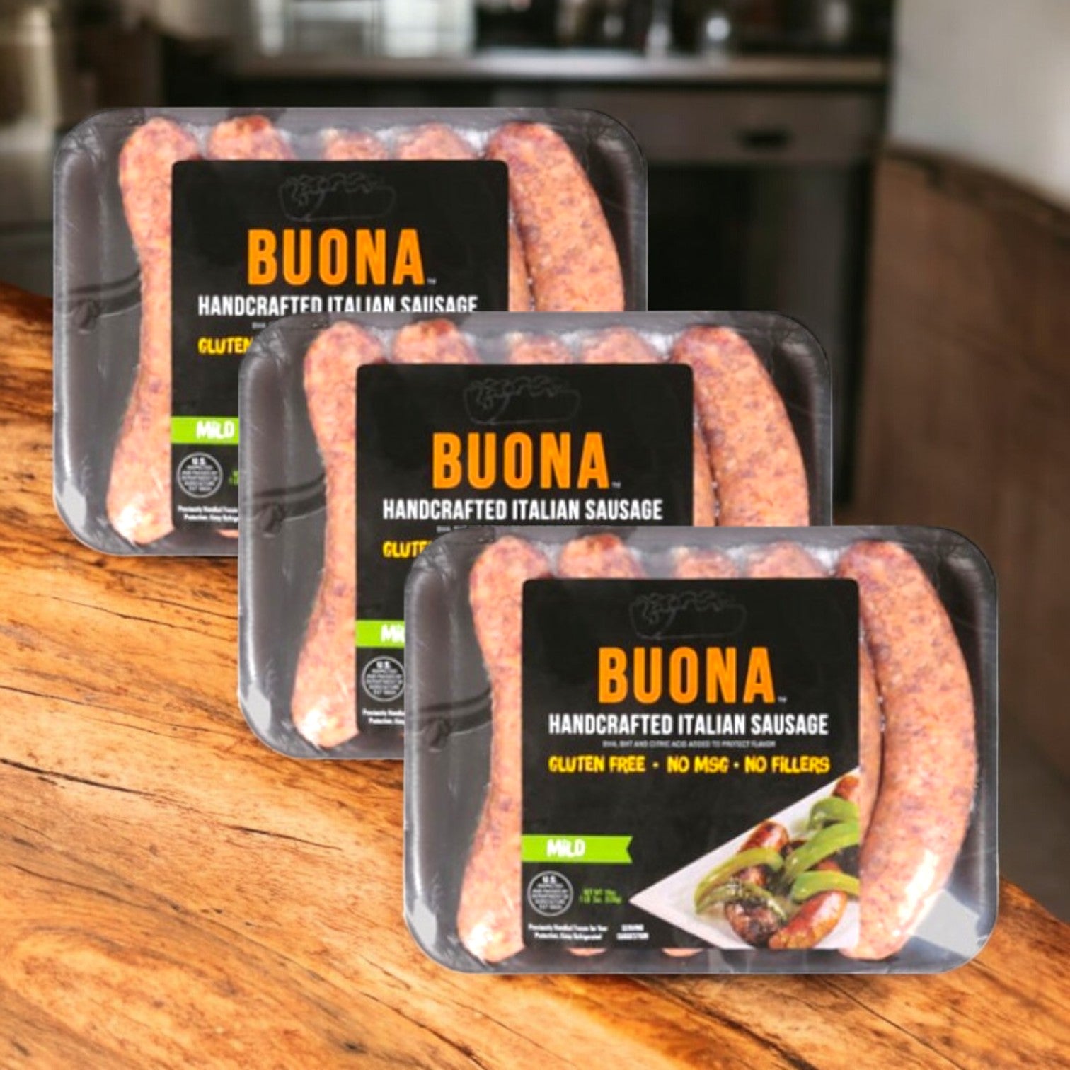 Three packages of Buona Italian Sausage – Handcrafted, Mild (19 oz, 3 Cases) from Buona are displayed on a wooden counter in a kitchen.
