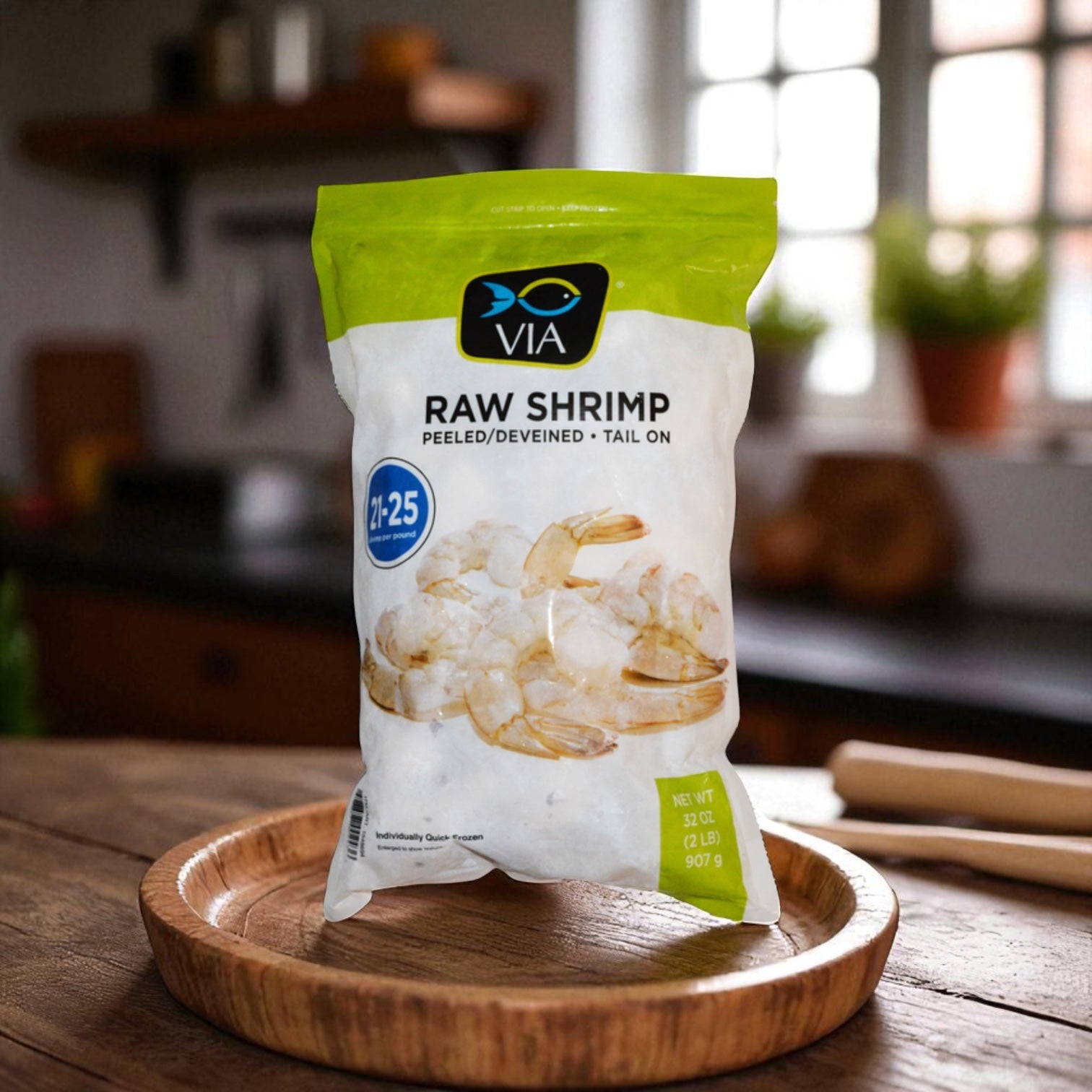 A 2 lb bag of Easy Lunches VIA Farm-Raised Raw Shrimp, Tail-On, Peeled, Deveined (21-25 ct) is displayed on a wooden plate in a cozy kitchen.