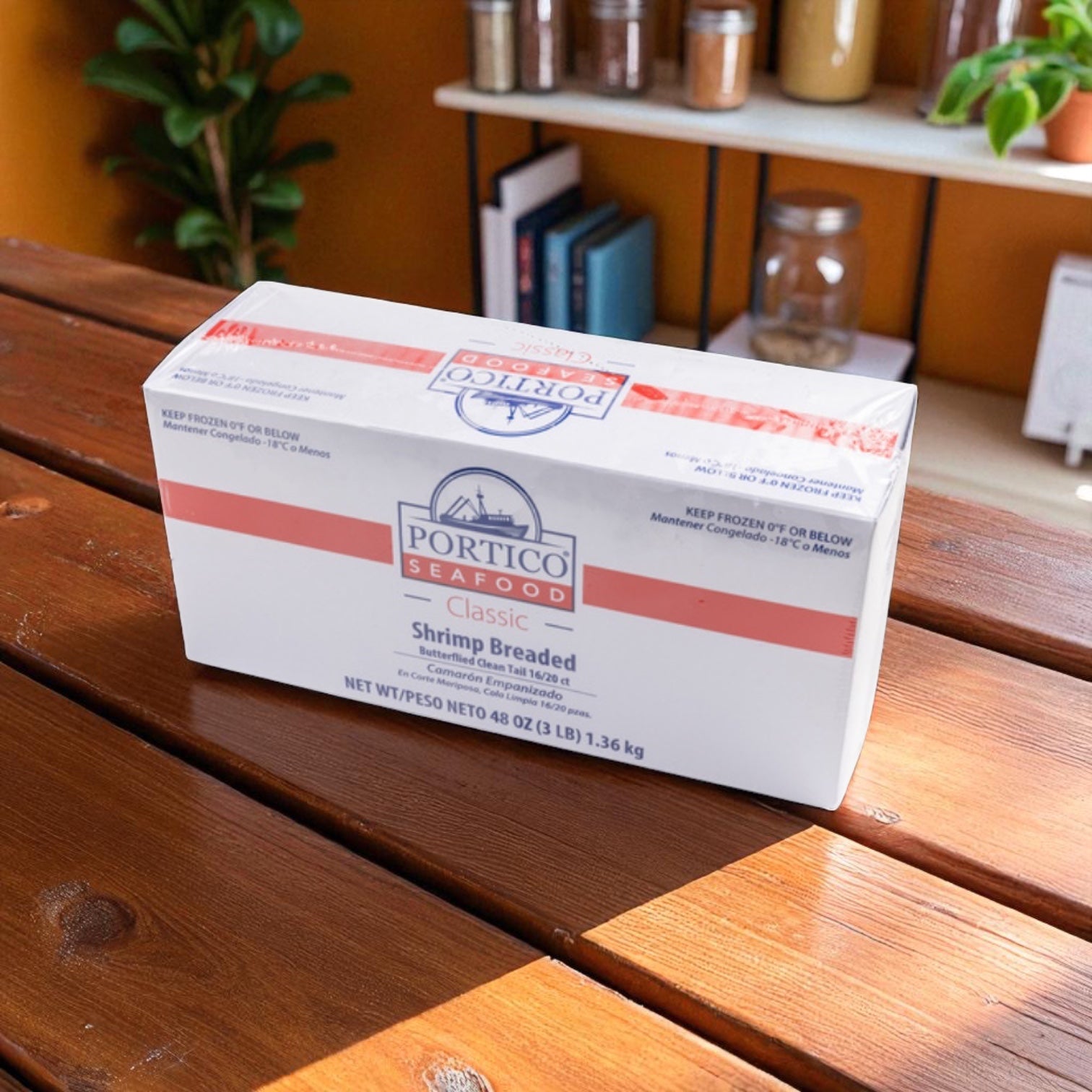A box of Sysco Shrimp Breaded Butterfly Clean Tail 3 lb - 4 Count sits on a wooden table with sunlight shining from the left, highlighting the frozen shrimp; jars and plants are visible on shelves in the background.
