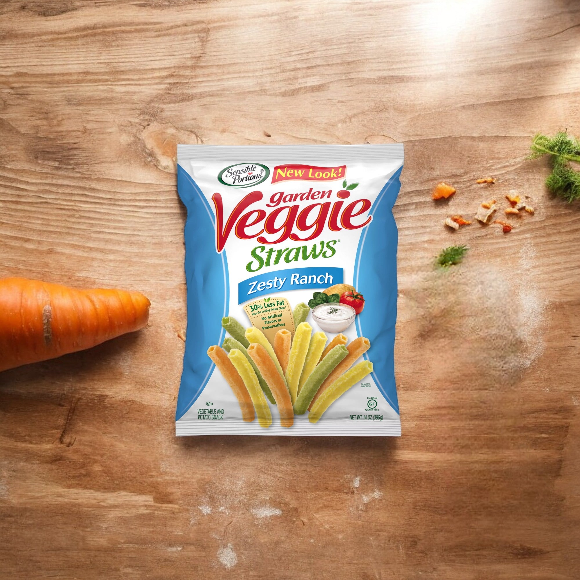 A bag of "Garden Veggie Straws Gluten-Free Zesty Ranch - 1 oz - 1 Count" by Hain Celestial, a delicious gluten-free snack, lies on a wooden surface near a carrot and pieces of herbs.