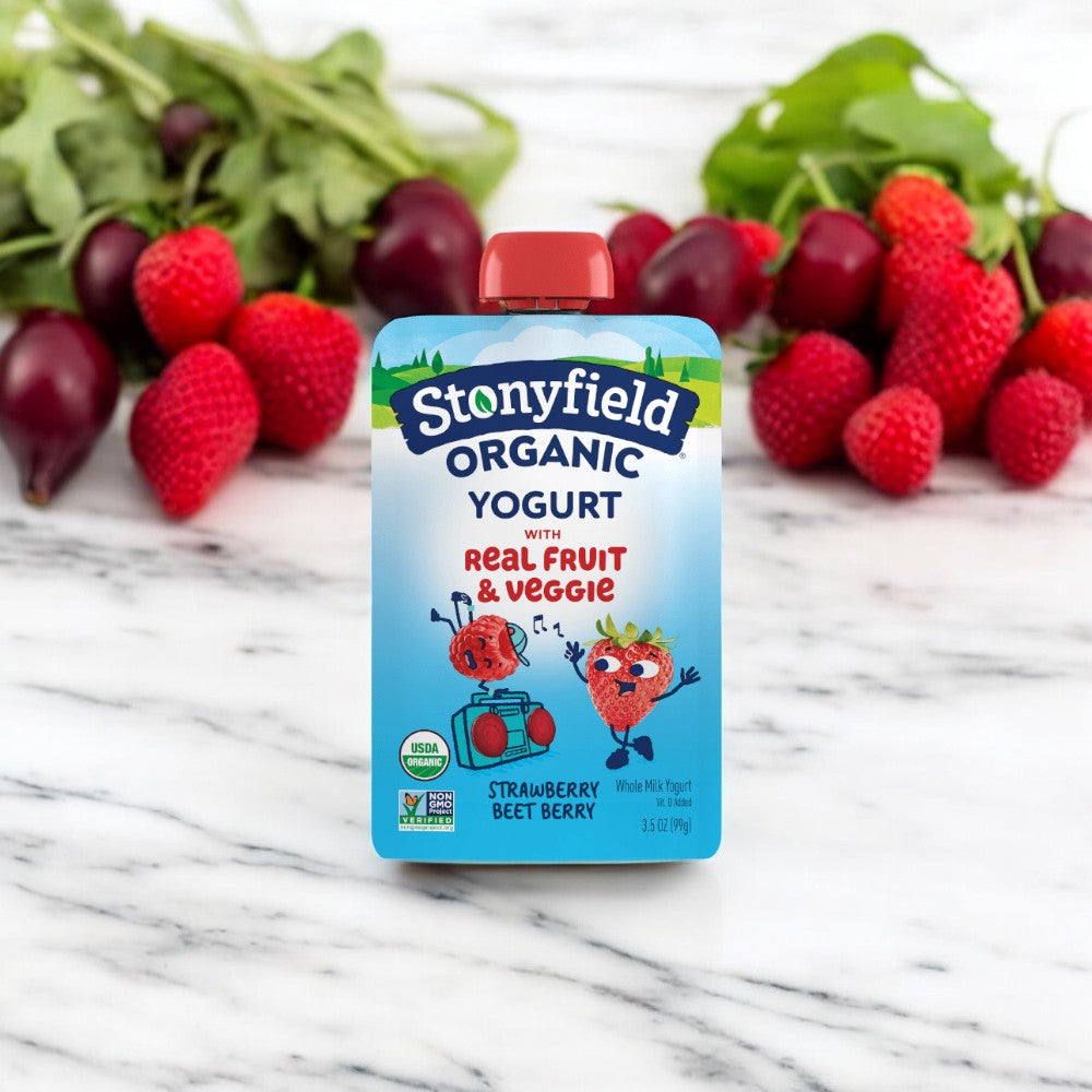 A Stonyfield's Organic Strawberry Beet Berry Kids' Yogurt pouch with an illustration of organic strawberries and beets on the front, set against a background of fresh strawberries and beets, featuring live active cultures for a probiotic boost.