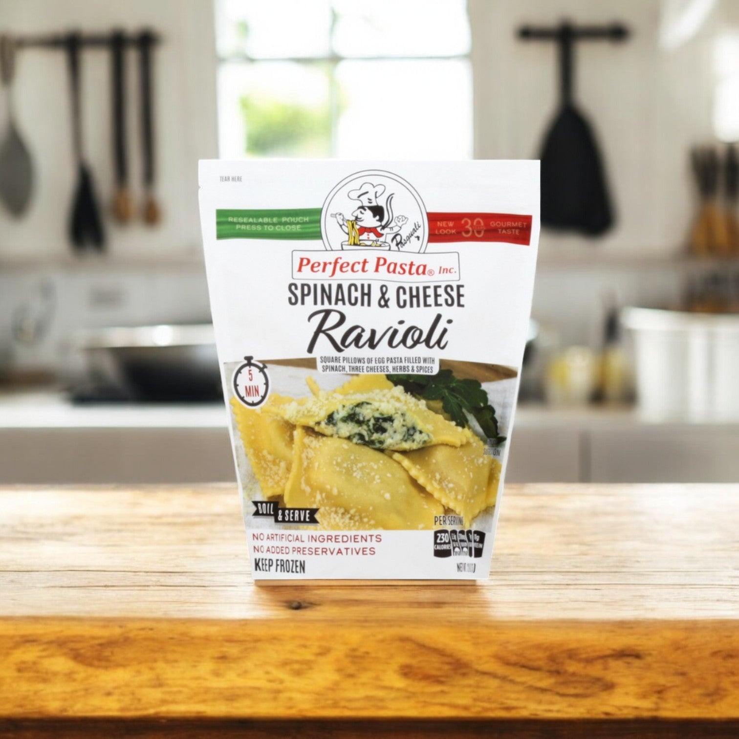 The Perfect Pasta Ravioli, Spinach & Cheese-1 Pack from Perfect Pasta sits on a wooden countertop in a cozy kitchen, offering vibrant green spinach and creamy cheese-filled frozen pasta for an authentic Italian-inspired taste experience.
