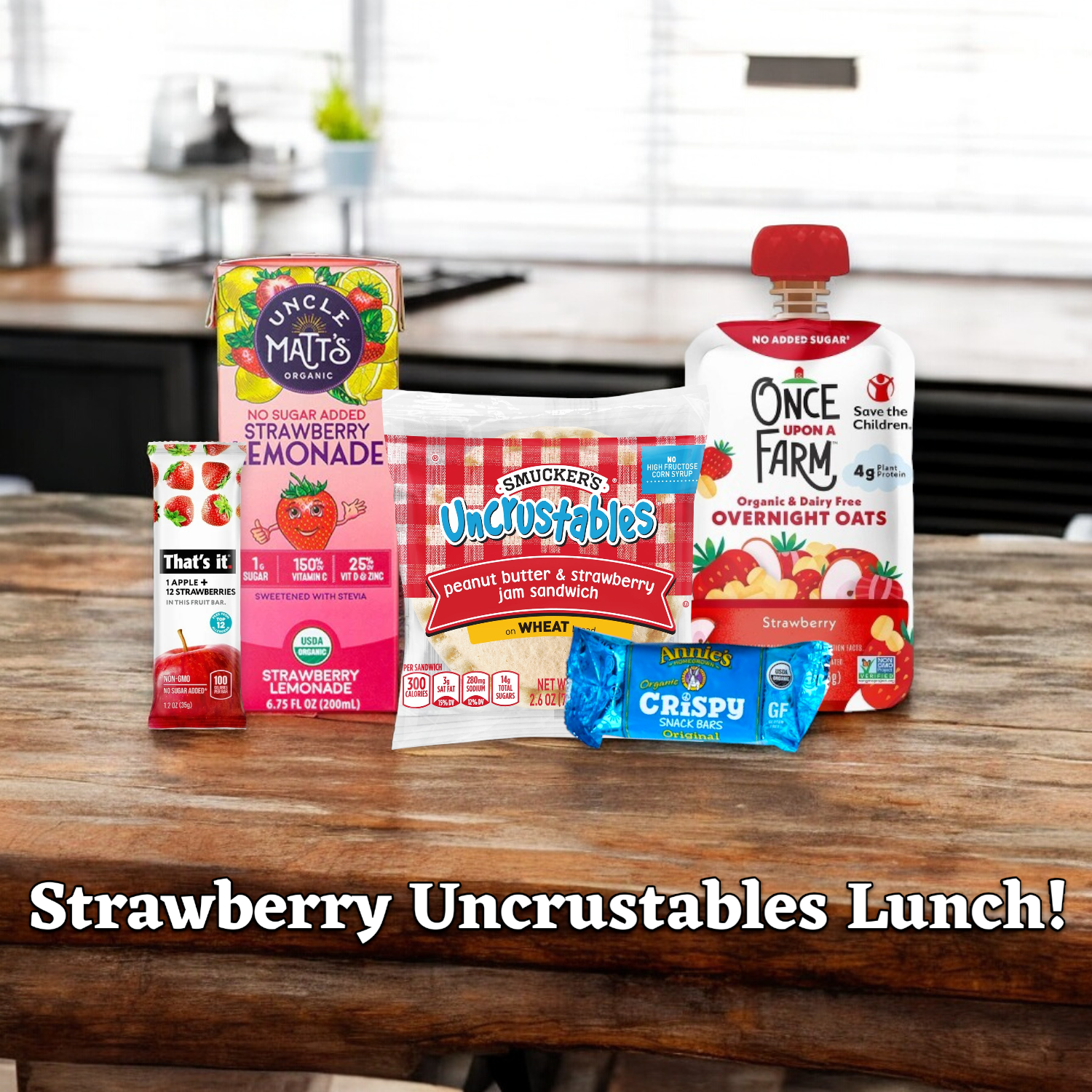 Displayed on a kitchen counter under the heading "Strawberry Uncrustables Lunch!" is a variety of strawberry-flavored snacks and drinks, including a Strawberry Uncrustables sandwich, Uncle Matt's Strawberry Lemonade Juice Box, That's it Strawberry Fruit Bar, Annie's Crispy Bar, and Once Upon A Farm Strawberry Overnight Oats—courtesy of Easy Lunches.