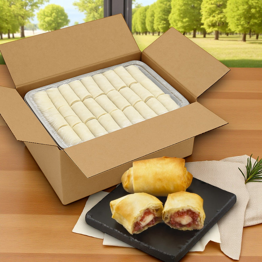 A box of Portico Classic Seafood’s Appetizer Brie with Raspberries in Phyllo (Sysco Imperial, 100 count) sits on the table; two filled appetizers are plated on a black dish in front.