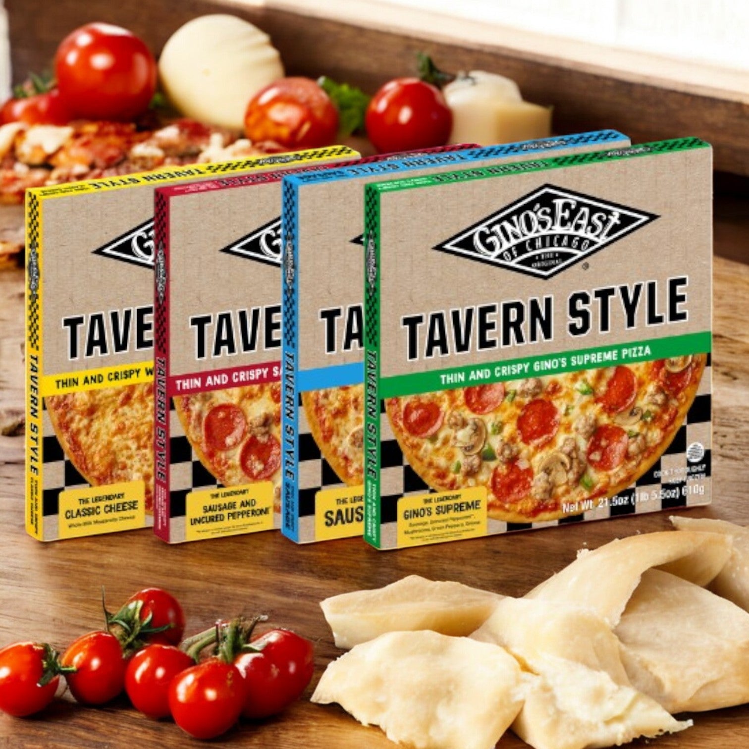 Three boxes of Gino's East Tavern Style Combo 4 Pack! are displayed with fresh tomatoes and cheese slices on a wooden surface, showcasing the classic Chicago thin-crust essence by Gino's East Pizza.