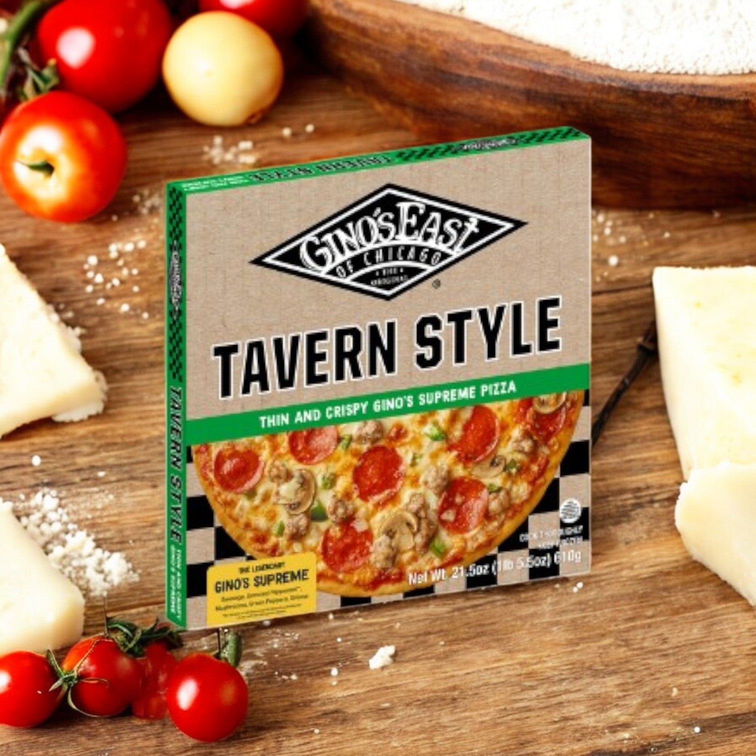 A Gino's East Tavern Style Combo 4 Pack box sits on a wooden table surrounded by cheese, tomatoes, and flour.