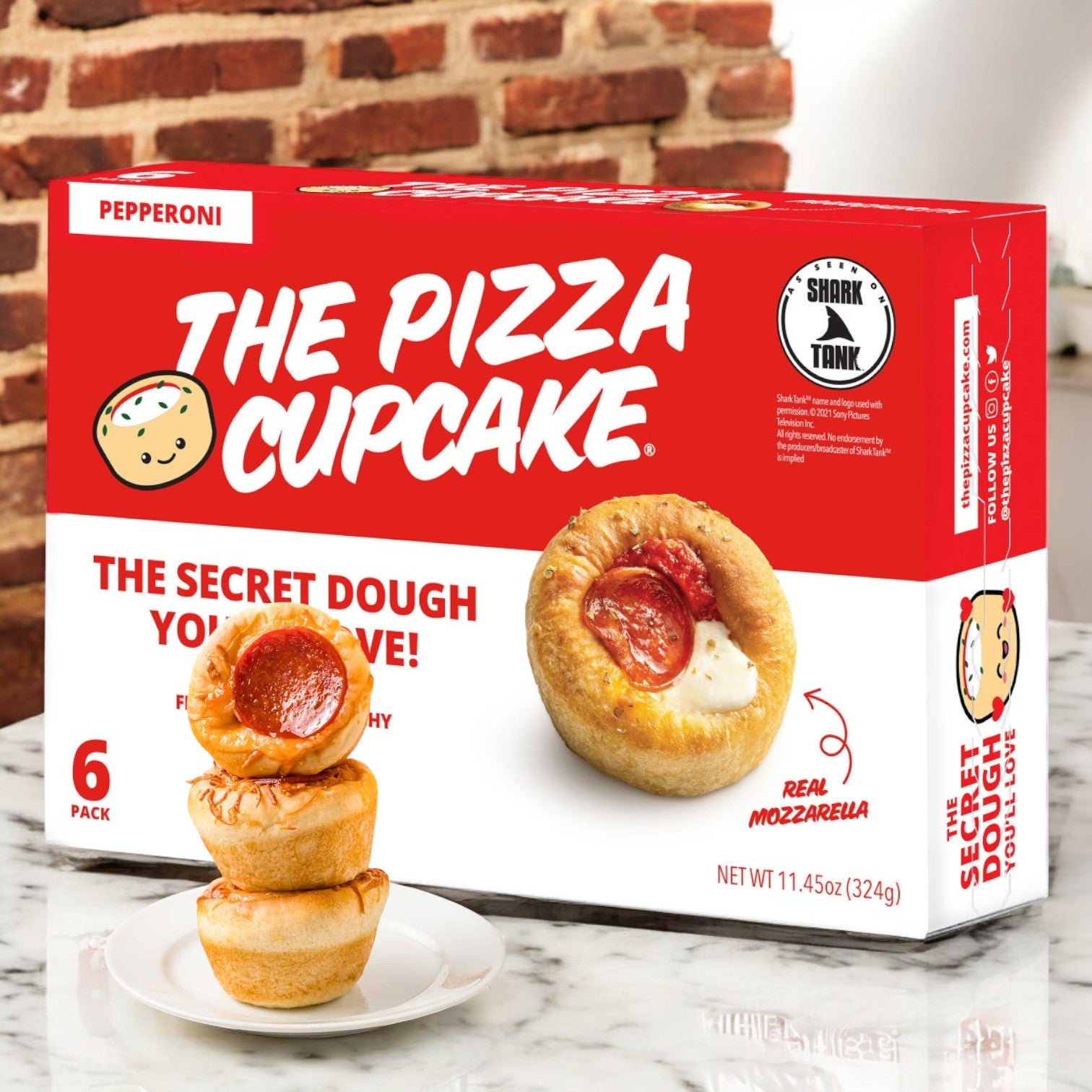 The Pizza Cupcake Pepperoni- 1 Count is displayed, ideal for on-the-go snacking, featuring three in front. Packaging highlights Shark Tank and touts secret dough with real mozzarella for an authentic taste, courtesy of The Pizza Cupcake brand.