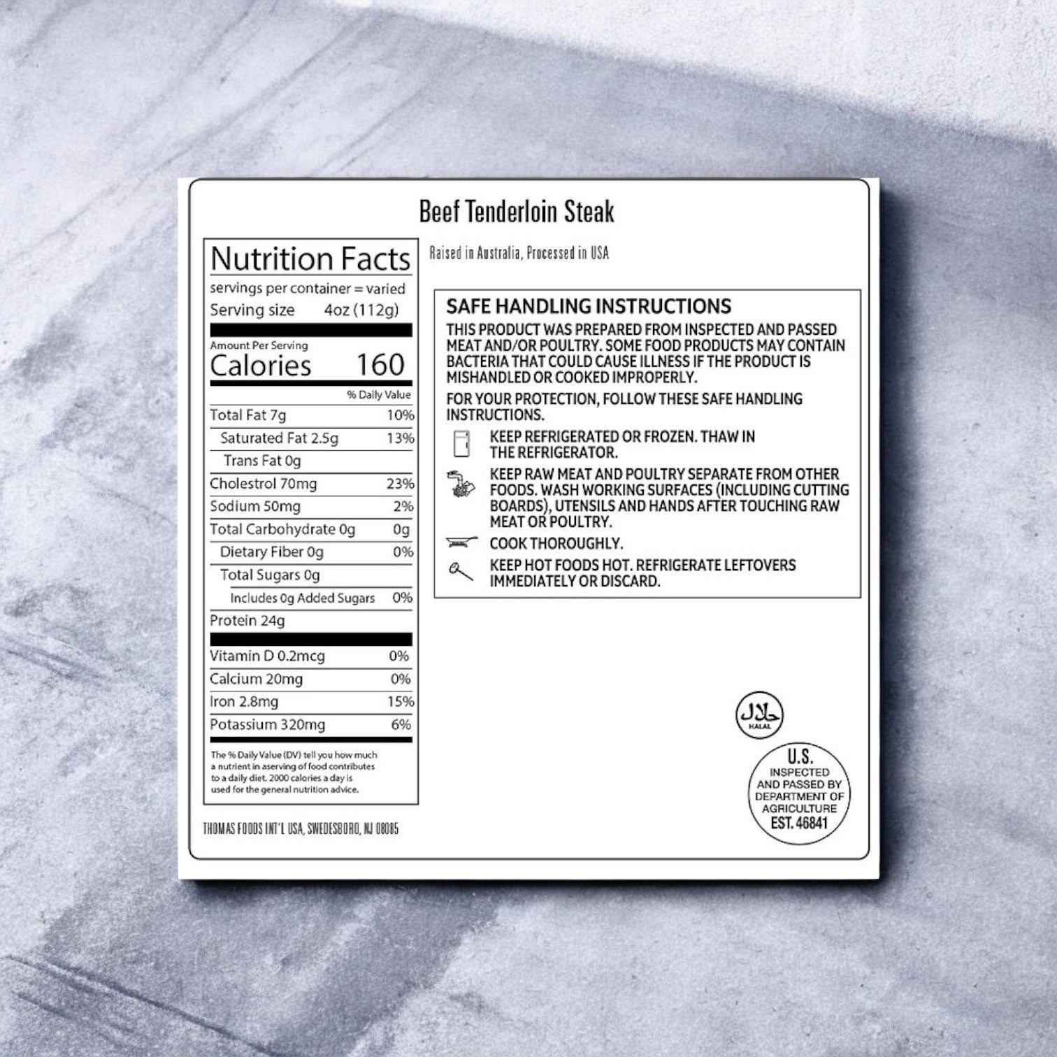 Label on a package of Thomas Farms Tenderloin Beef Steak featuring nutrition facts, safe handling instructions, USDA inspection mark, and storage guidelines on a gray background. Ideal for gourmet dining enthusiasts desiring premium quality and exceptional taste in every bite.