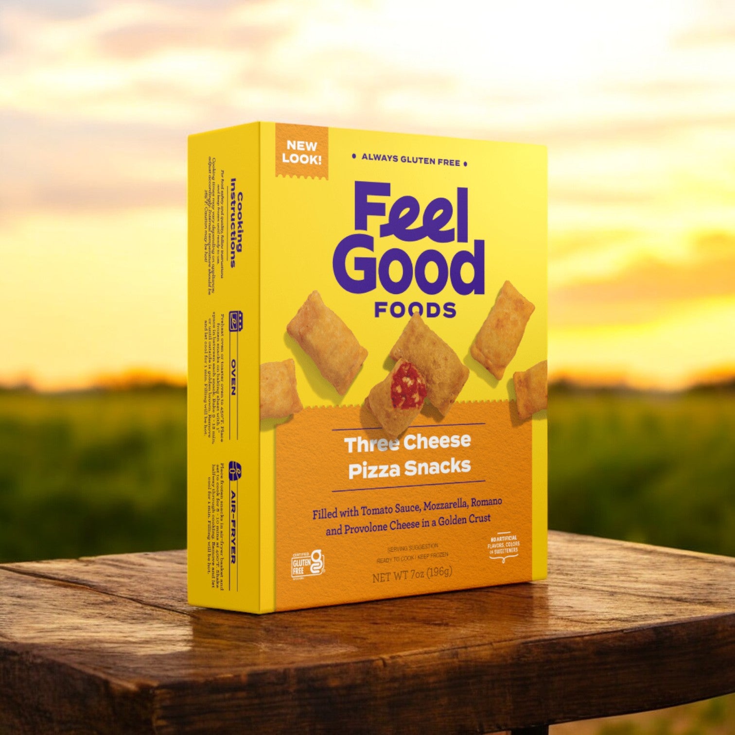 A 7 oz box of Feel Good Foods Three Cheese Pizza Snacks is placed on a wooden table outside, set against a sunny landscape backdrop.