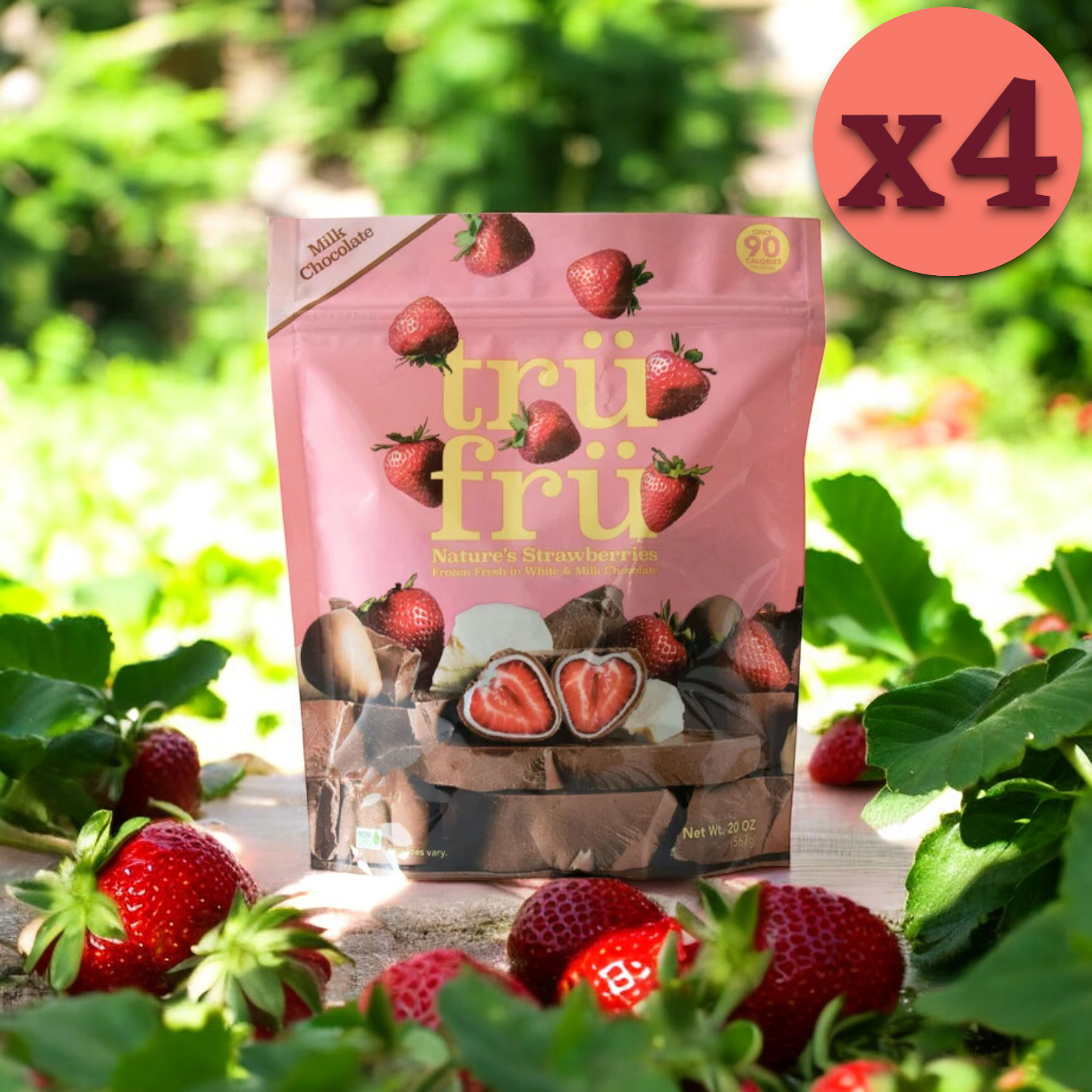 A package of Tru Fru Milk Chocolate Strawberries, 20 oz. - 4 Count, featuring delicious freeze-dried strawberries coated in rich milk chocolate, is surrounded by fresh strawberries. A circular label in the top right corner indicates a quantity of four (x4).