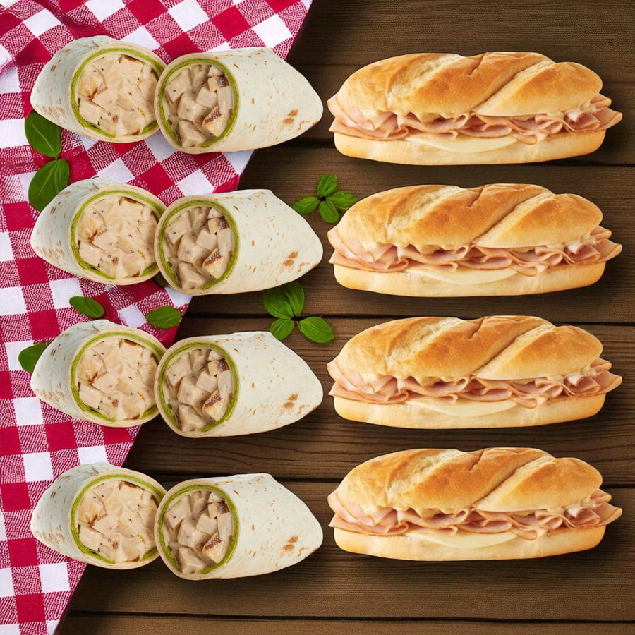 Eight individually wrapped E.A. Sween Market Sandwiches—4 Chicken Caesar Wraps (8.6 oz) and 4 Turkey & Provolone Subs (6 oz)—are arranged on a wooden surface with a red and white checkered cloth in the corner.