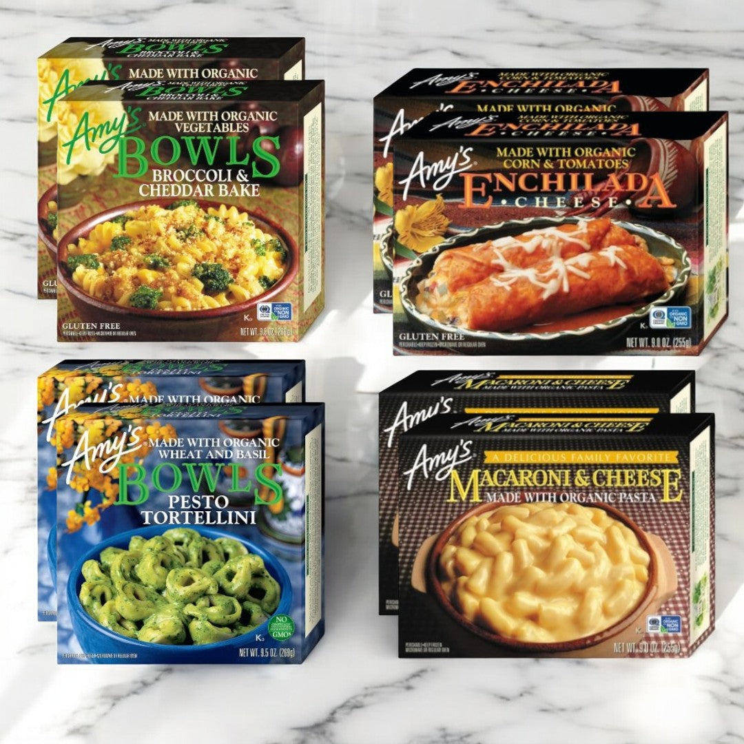 On a marble surface, discover Amy's expansive frozen meal selection featuring two Broccoli & Cheddar Bowls, two Enchilada Cheese Bowls, two Pesto Tortellini Bowls, and two Macaroni & Cheese Bowls. Presenting Amy's Variety Bowl Bundle—wholesome and hearty meals made with organic ingredients, including gluten-free options!