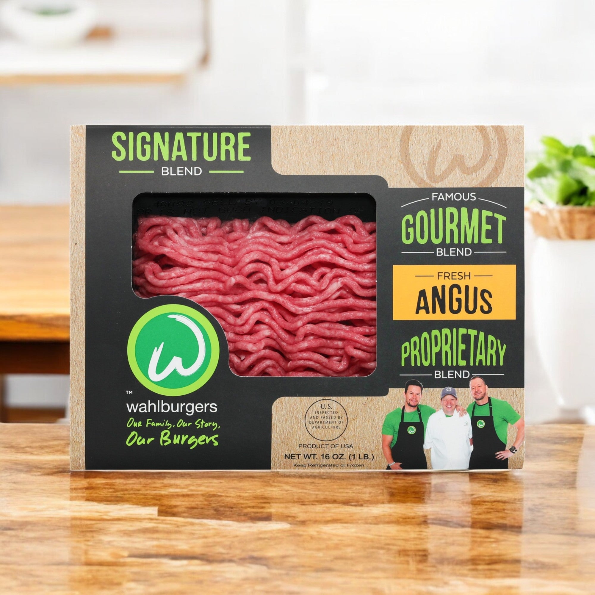 Savor the rich flavor of Wahlburgers Signature Blend Loaf, made from premium Angus beef. The packaging features three people with green accents on a wooden background. Comes in 16 oz, 3-count packs.