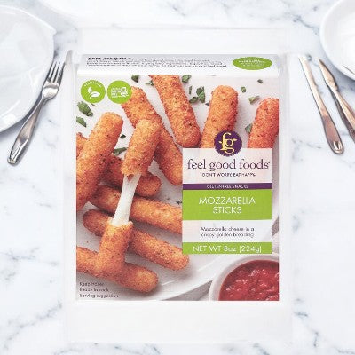 Package of Easy Lunches' Feel Good Foods Mozzarella Sticks (8 oz) on a white table with a couple of empty plates and utensils beside it.