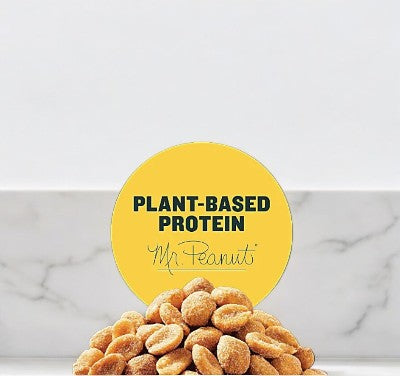 A pile of Planters Honey Roasted Peanuts, with a circular yellow sign that reads "Plant-Based Protein Mr. Peanut," is in front of them.