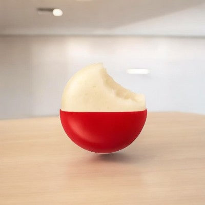 A Mini Babybel Original Semisoft Cheese wheel from Babybel, featuring its signature small, round shape and red wax coating, with a bite taken out to reveal its creamy texture. It rests on a light wood surface in a softly blurred indoor setting.