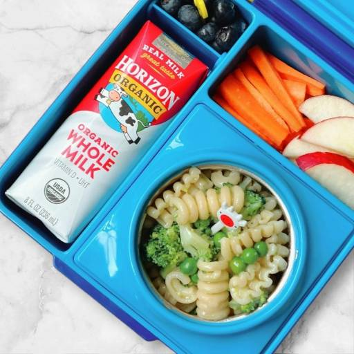 A blue lunchbox containing a Horizon Organic Whole Milk - 8 oz- 1 Count from the brand Horizon, blueberries, carrot sticks, apple slices, and a pasta with broccoli dish.