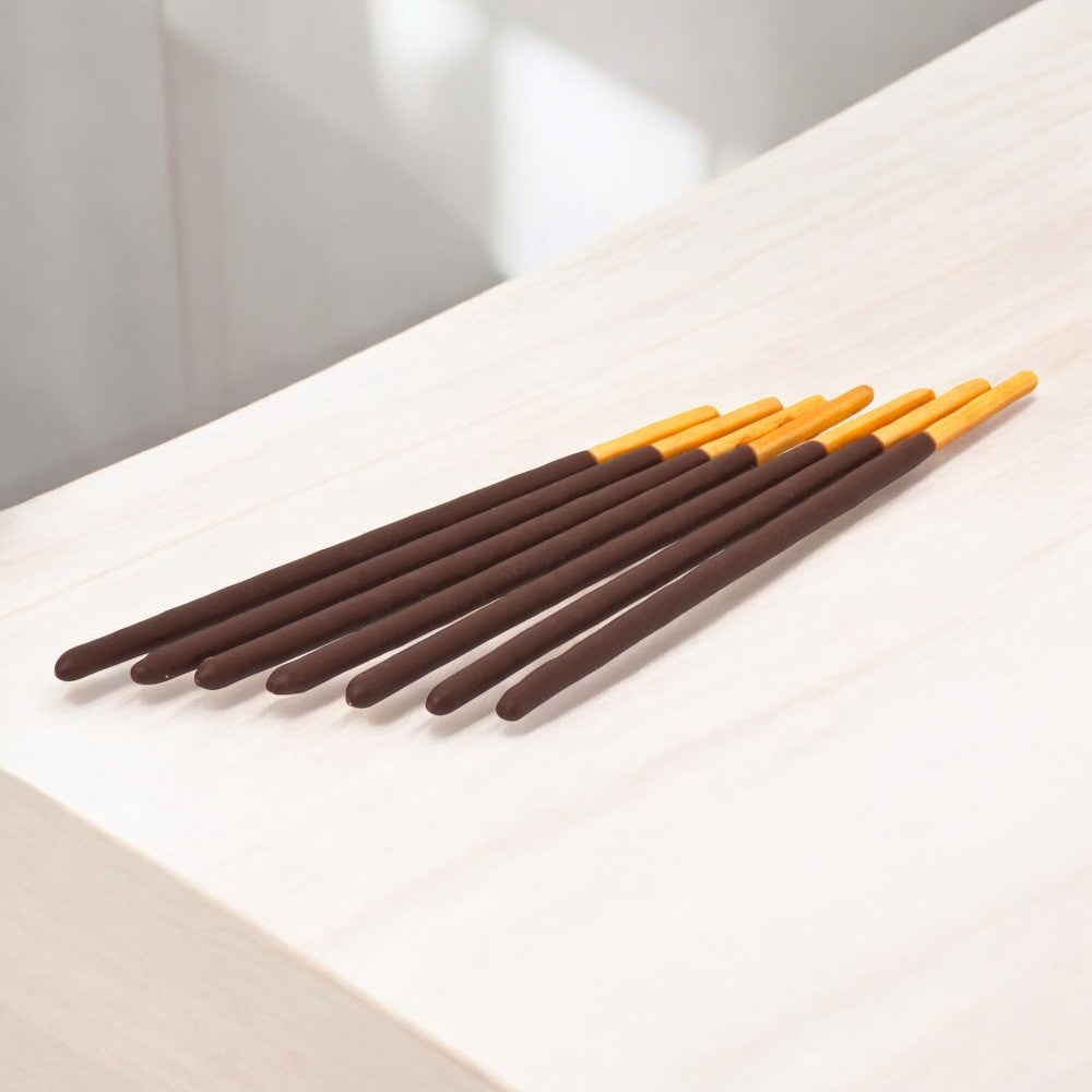 A row of Pocky Chocolate Cream Covered Biscuit Sticks, from the iconic brand Pocky, is neatly arranged on a light wooden surface.