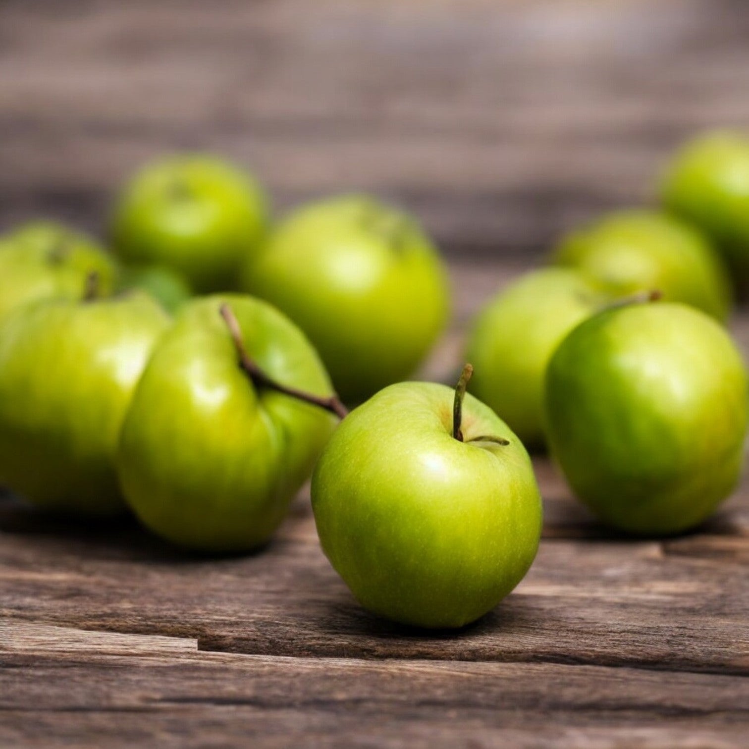 Several Easy Lunches Organic Green New Zealand Apples scattered on a wooden surface.