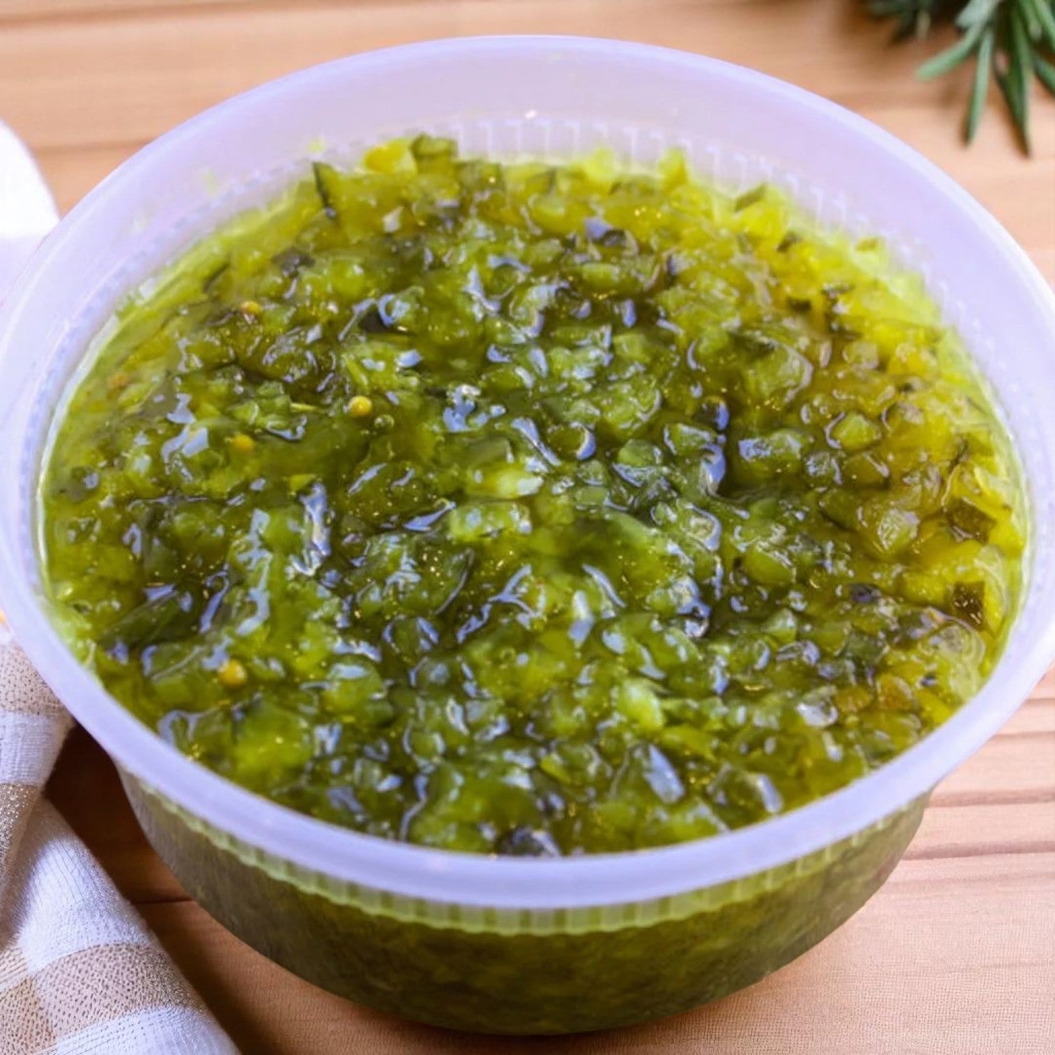 A 1-gallon container of Vienna Beef Chicago-Style Green Relish sits on a wooden surface, capturing the signature neon green topping found on classic Vienna Beef hot dogs.