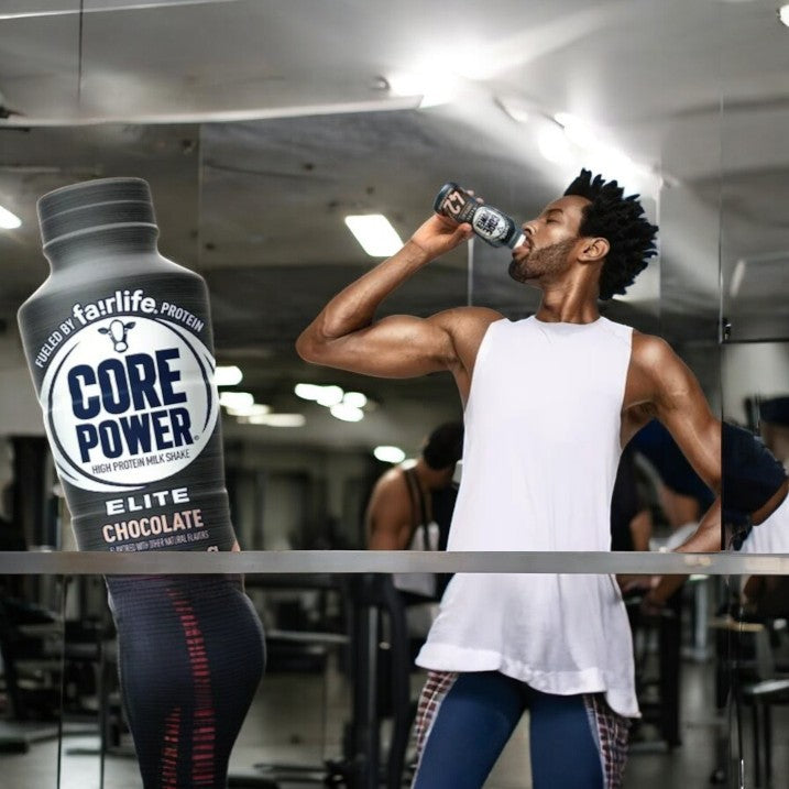 At the gym, someone savors a Fairlife Core Power Elite 42g Protein Shake, Chocolate, from FairLife's selection, using ultra-filtered milk to aid in muscle recovery as they stand by the workout equipment.