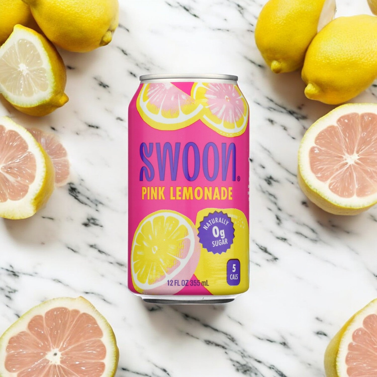 A can of Swoon Pink Lemonade from Swoon sits on a marble surface, surrounded by halved lemons and pink grapefruits. This sugar-free beverage boasts "0g Sugar" and "5 Calories," naturally sweetened with monk fruit.